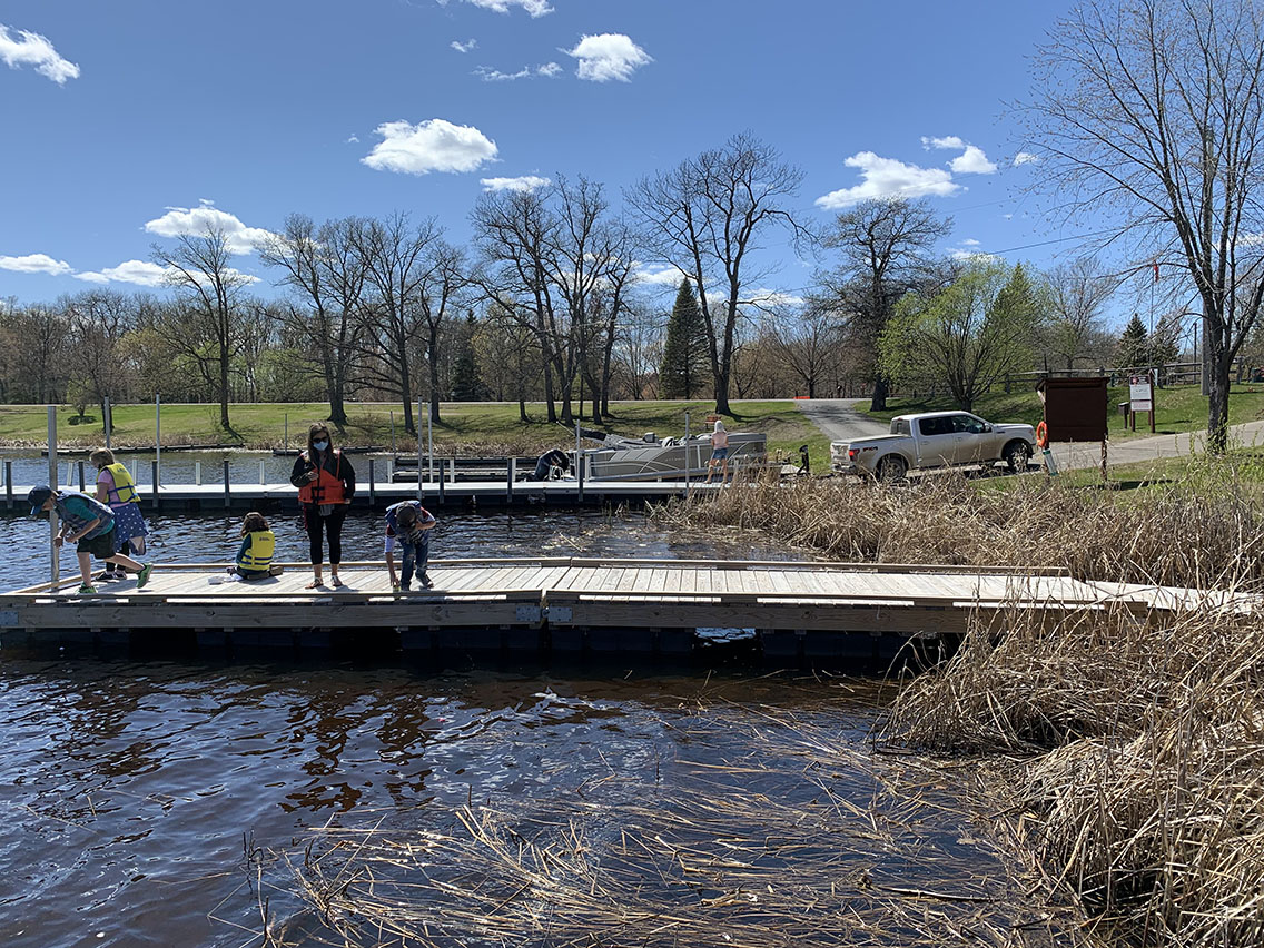 People fish off of a dock on a lake