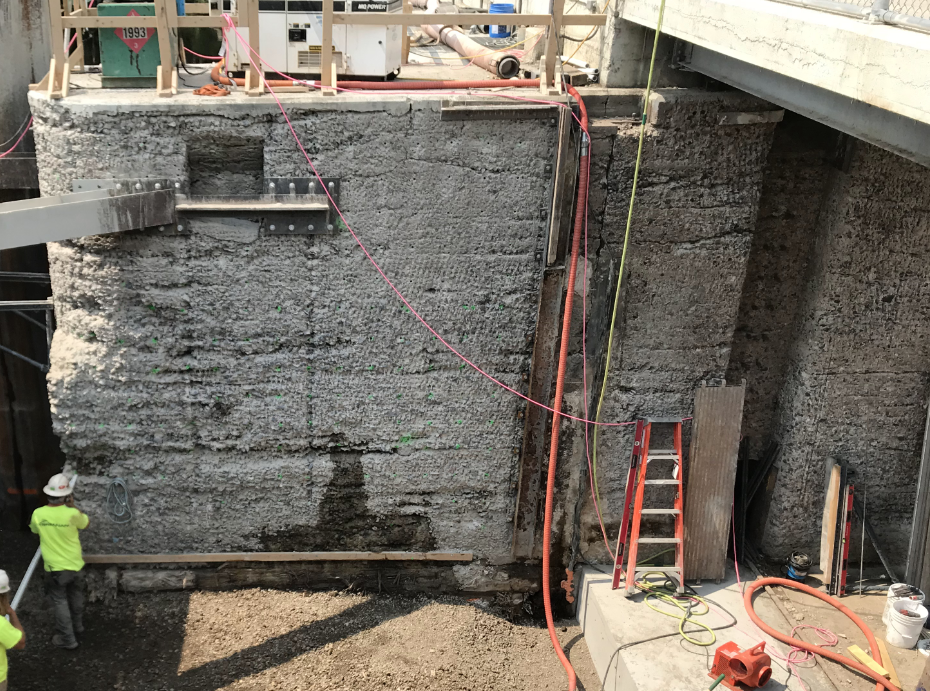 A person works on a large concrete wall