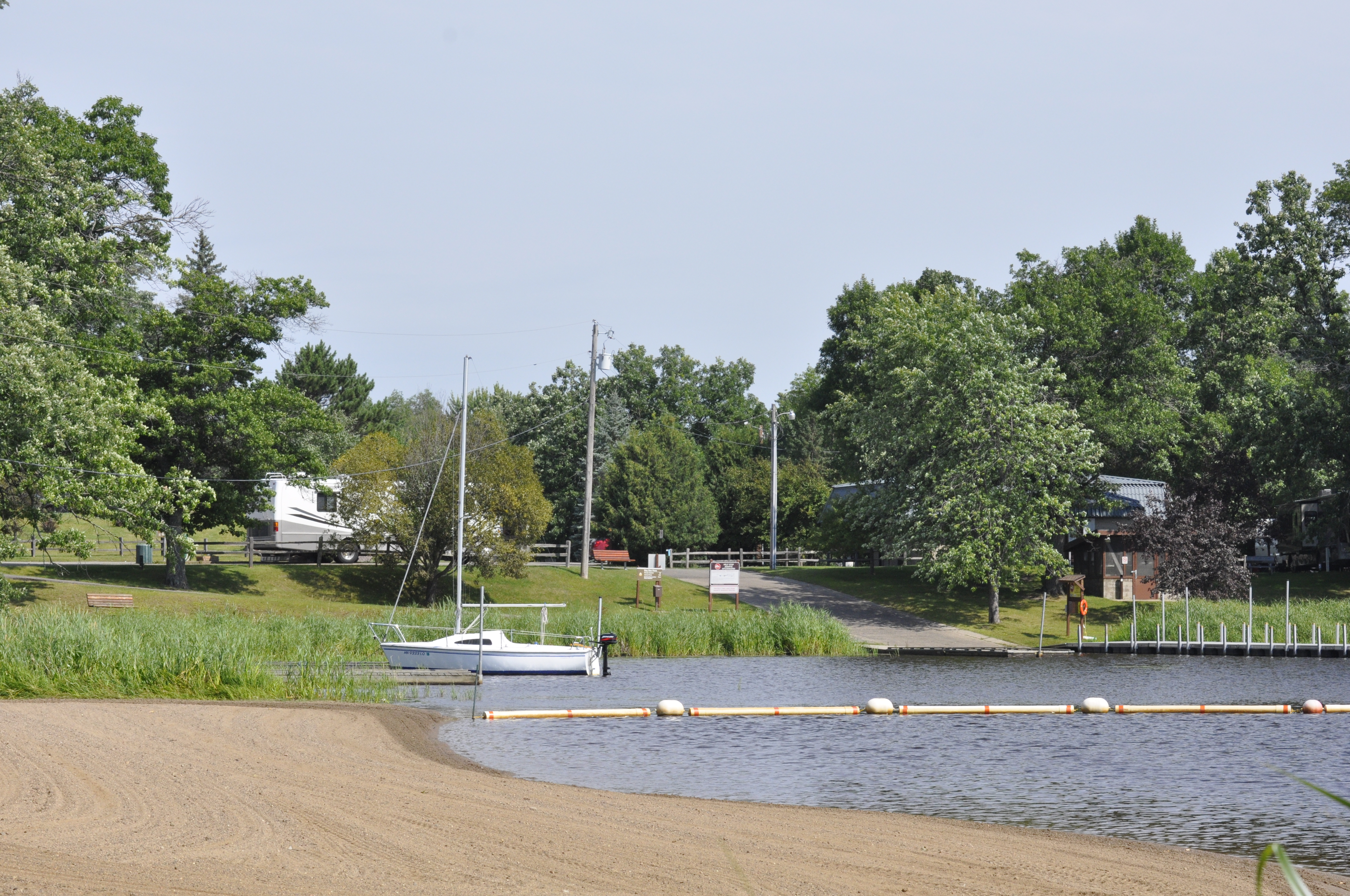 A boat ramp on a lake and a sandy beach
